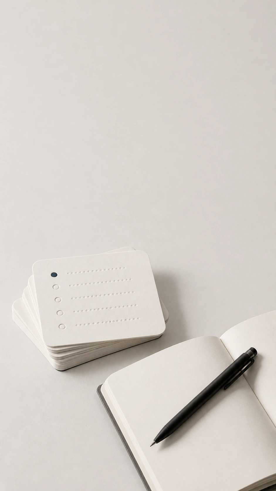 Workshop cards, notebook, and black pen on a light studio background